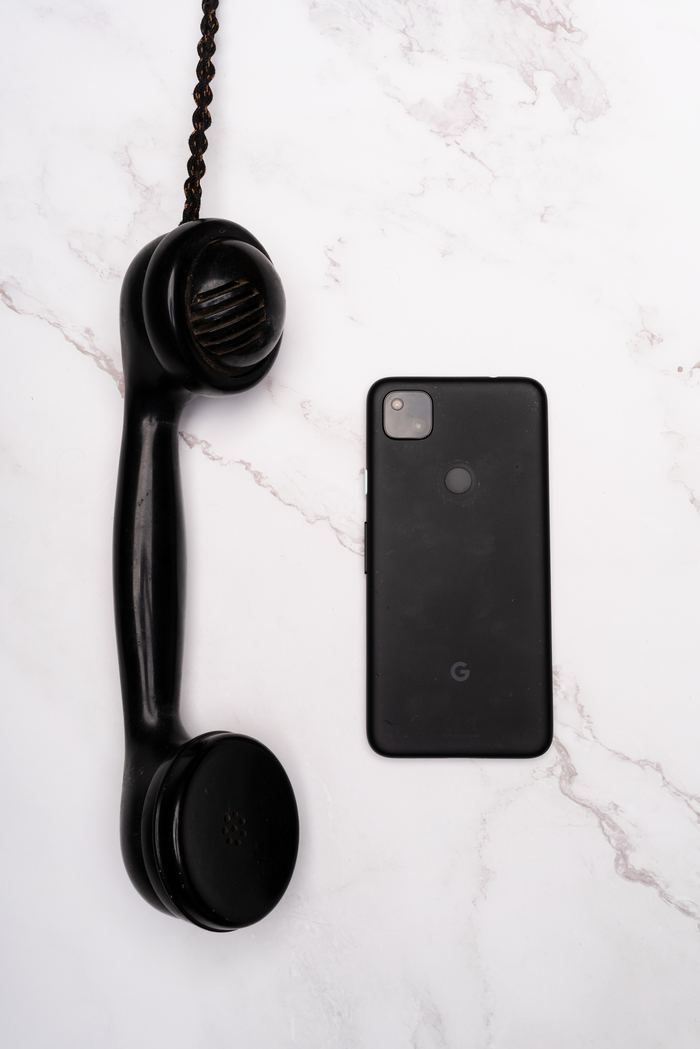 Altes Telefon neben modernem Smartphone